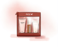 A red Aptar Beauty gift box contains three skincare products in mini packaging: two cream tubes and one bottle with a pump labeled MiniCream, all elegantly displayed against a soft pink background.