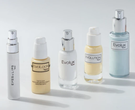 Five skincare product bottles of varying shapes and sizes, each labeled with names like EYES & LIPS which is a micro-dosage cosmetic pump, EvoLock, Evolux, and EVOLUTION, arranged in a row on a white surface.