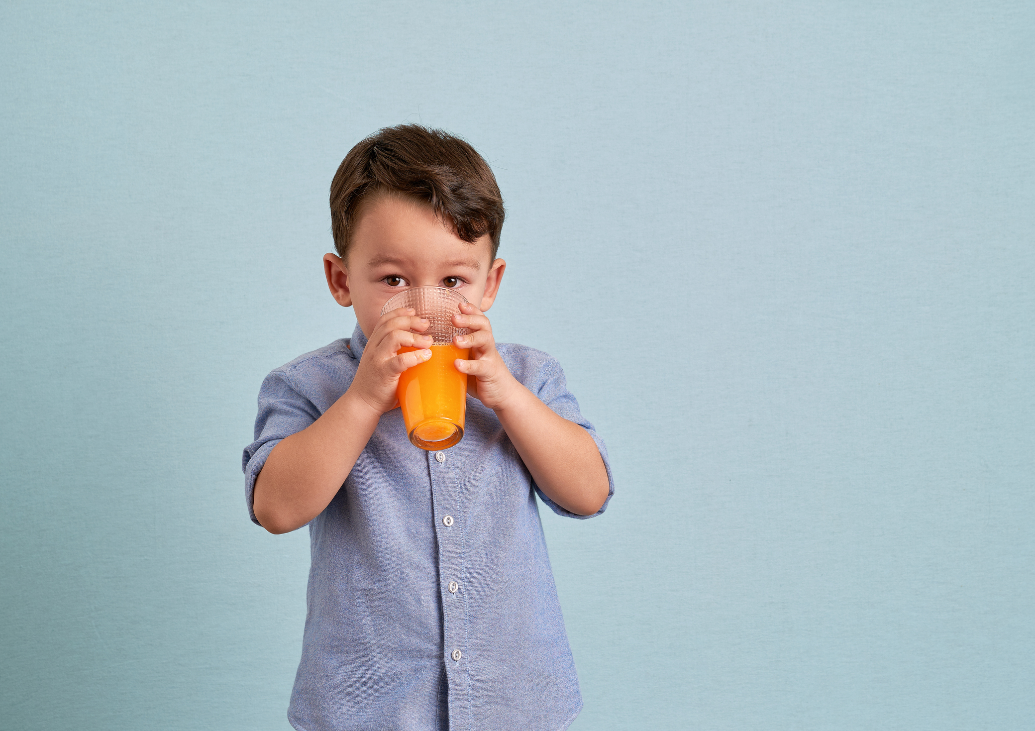 Little boy drinking juice from a glass