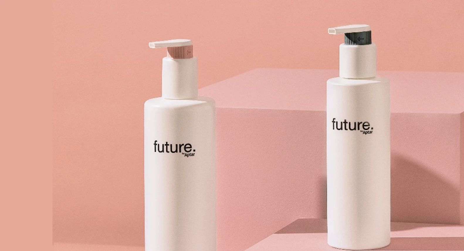 Two white pump bottles labeled future, a fully recyclable dispensing pump are displayed on pink platforms against a pink background, creating a minimal and modern aesthetic.