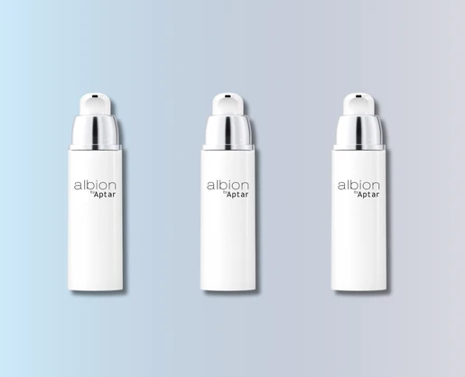 Three identical white skincare bottles with silver caps are arranged in a row against a gradient background, showcasing albion Aptars sleek airless beauty packaging. The background fades from light blue on the left to light gray on the right.