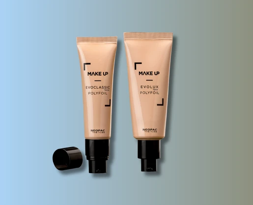 Two beige tubes labeled MAKE UP with black caps, one cap removed, displayed on a blue-to-gray gradient background. These EVOCLASSIC POLYFOIL and EVOLUX POLYFOIL by NEOPAC are ideal as airless pump tubes for skincare and cosmetic formulas.