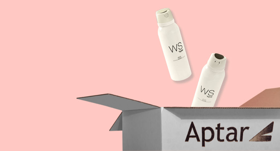 Two white spray bottles labeled WS, with Bicolor Aerosol Actuators, hover above an open cardboard box with the word Aptar printed on the side, set against a light pink background.