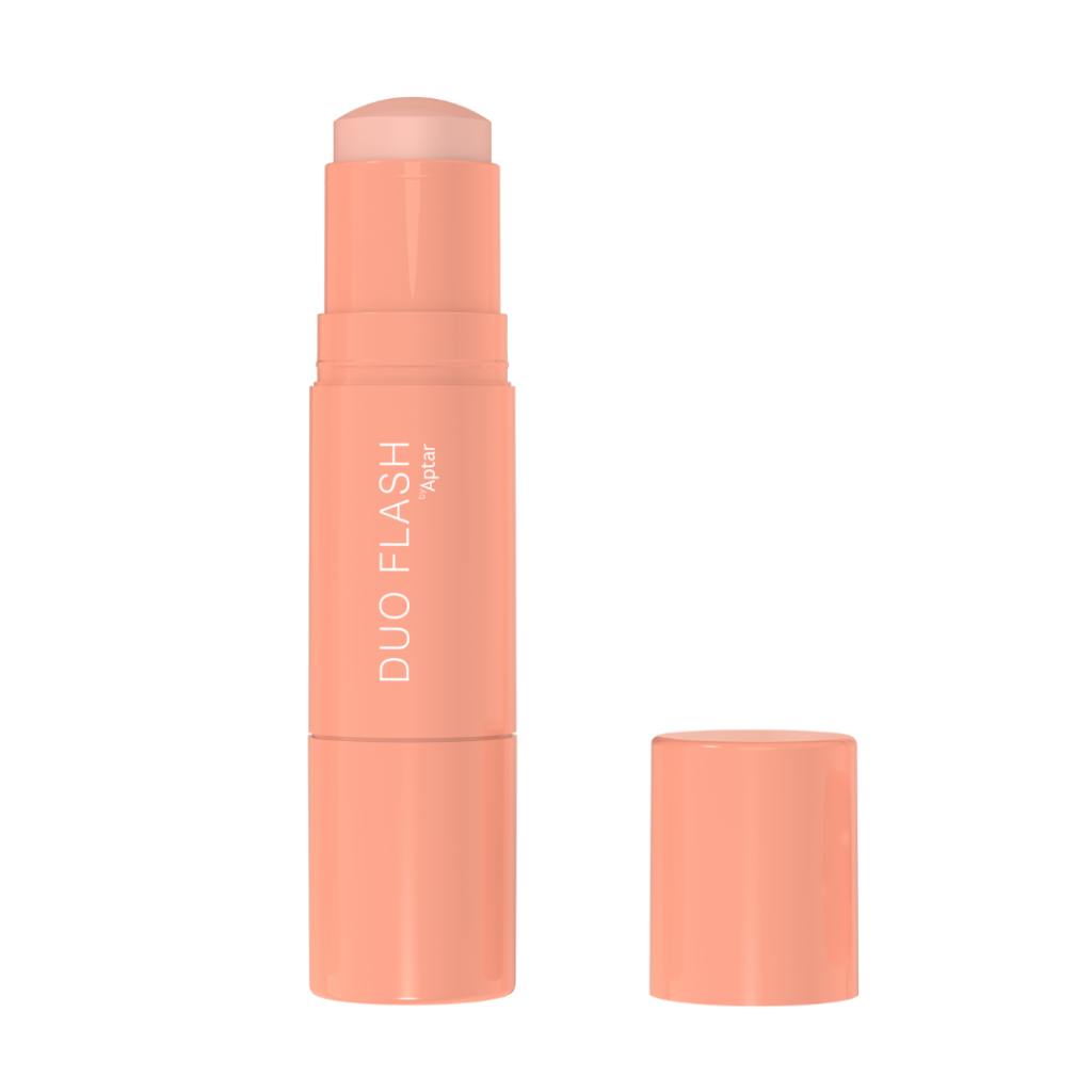 A peach-colored mono-material face stick labeled DUO FLASH by Aptar with its cap removed and placed beside it, revealing the solid product inside.