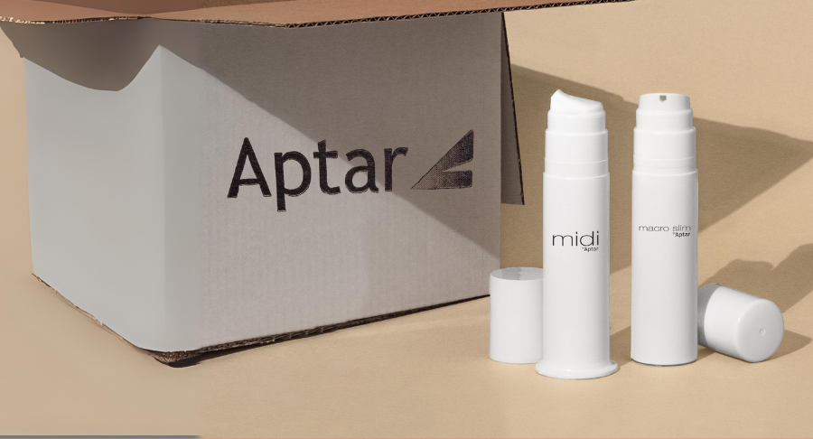A cardboard box labeled Aptar sits next to two white plastic bottles labeled Midi and Macro Slim, designed with airless packaging for high-viscosity formulas, with their caps placed nearby on a beige background. The image indicates the products are designed for omnichannel shipping needs.
