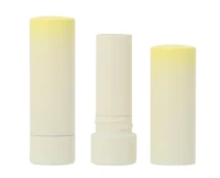 Three white non-guided lipsticks packaging with pale yellow tops are shown standing upright against a plain white background. The middle tube is open, revealing the balm inside.