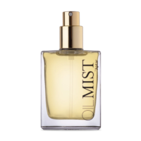 "Clear rectangular bottle with a gold spray pump for dry oils, labeled 'OIL MIST by Aptar' and filled with pale yellow liquid, shown without a cap against a white background. "