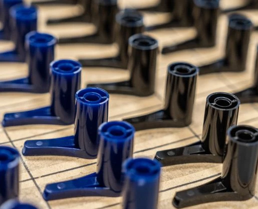 Close-up of blue and black dispensing pumps arranged on a wooden board with intersecting lines.