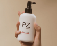 A black Spray Pump with Nozzle on a a white bottle labeled PZ Nozzler, against a neutral beige background.