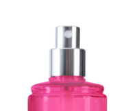 Close-up of the nozzle of a silver and pink spray bottle against a white background.
