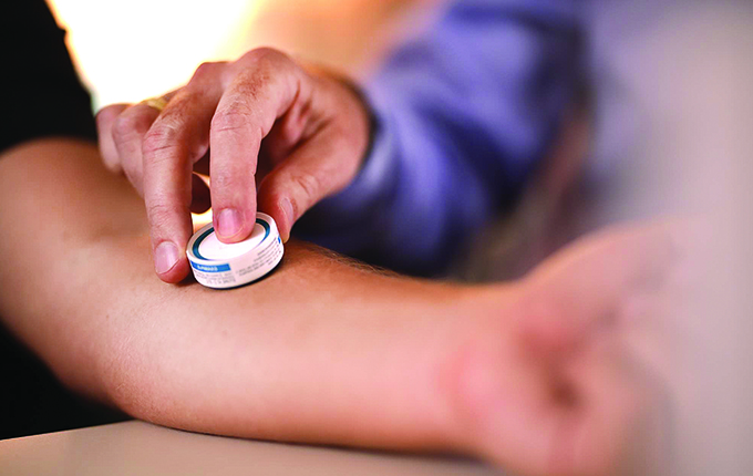 A person applying a Microarray Patch, an innovative needle-free drug delivery solution to a patient's arm.